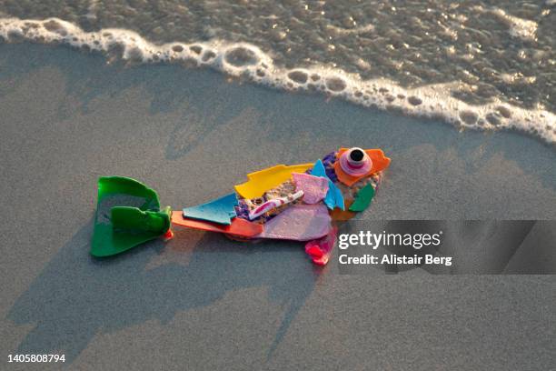 fish made from plastic washed up on a beach - sculpture by the sea imagens e fotografias de stock