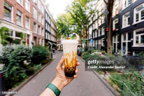 drinking iced cold bubble tea with tapioca pearls on the street, personal perspective view - brown sugar stock pictures, royalty-free photos & images