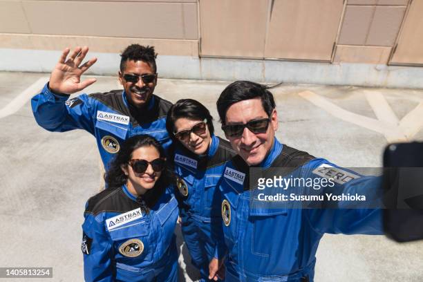 Four commercial space travelers taking selfie.