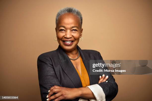 african american mature female ceo with arms crossed - female ceo stock pictures, royalty-free photos & images