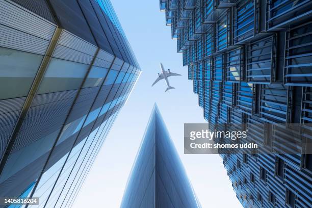 looking up at modern financial buildings with flying aeroplane - international centre stock-fotos und bilder