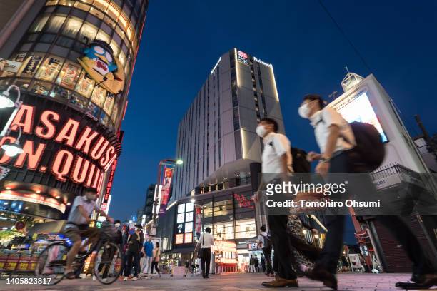 Pedestrians walk past the building housing the Asakusa Yokocho alley at night on June 29, 2022 in Tokyo, Japan. The newly-built restaurant gathering...