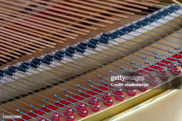 high angle view of piano strings - saite stock-fotos und bilder