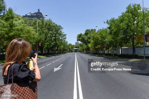 Woman photographs the 'Paseo de la Castellana' avenue in Madrid empty due to traffic cuts on the occasion of the NATO Summit, on 29 June, 2022 in...
