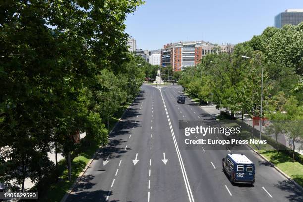 Dos furgones policiales circulan por la avenida ‘Paseo de la Castellana’ de Madrid, vacia por los cortes de trafico con motivo de la celebracion de...