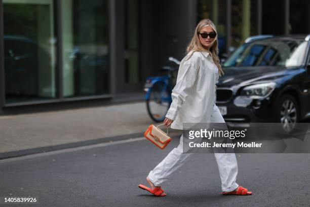 Katharina Bonmann seen wearing black sunglasses, a white crop top from NØNOUC studios, a white denim shirt jacket, a white denim jeans pants, an...