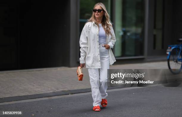 Katharina Bonmann seen wearing black sunglasses, a white crop top from NØNOUC studios, a white denim shirt jacket, a white denim jeans pants, an...