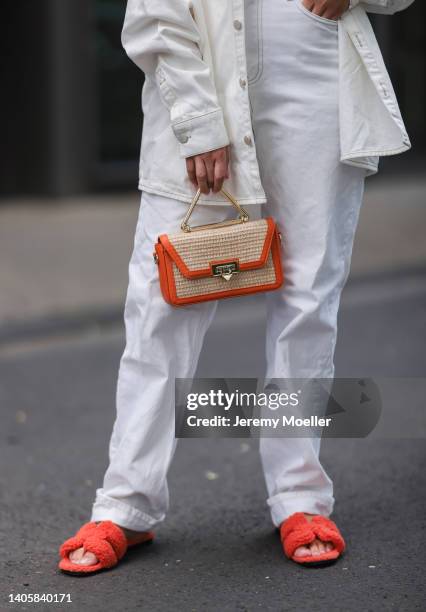 Katharina Bonmann seen wearing a white denim shirt jacket, a white denim jeans pants, an orange leather bast bag from Weat and red/orange fluffy...