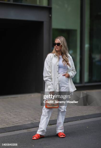 Katharina Bonmann seen wearing black sunglasses, a white crop top from NØNOUC studios, a white denim shirt jacket, a white denim jeans pants, an...