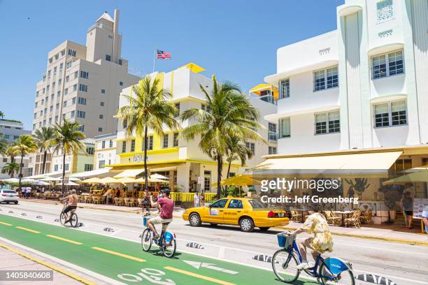 Miami Beach, Florida, Ocean Drive Art Deco District, bike lane bicyclists on citibikes near hotels and taxi cab.