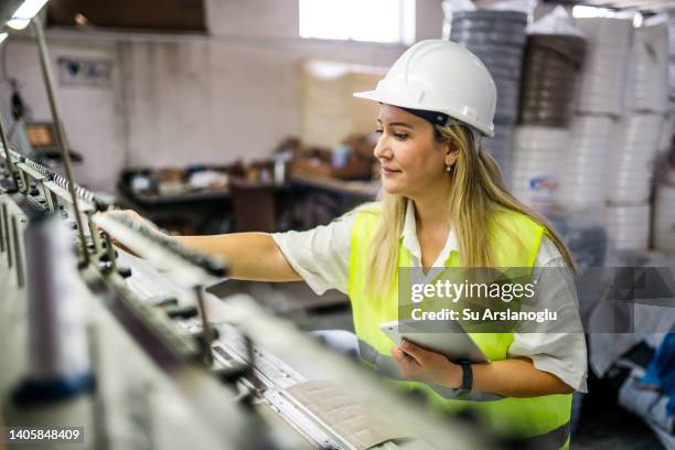 female engineer working with manufacturing equipment in a factory - communication occupation stock pictures, royalty-free photos & images