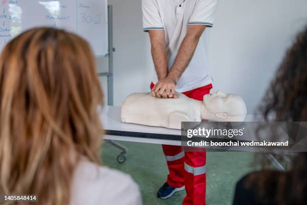 in the first-aid class, practice chest compressions on a cpr training dummy. - doll bildbanksfoton och bilder