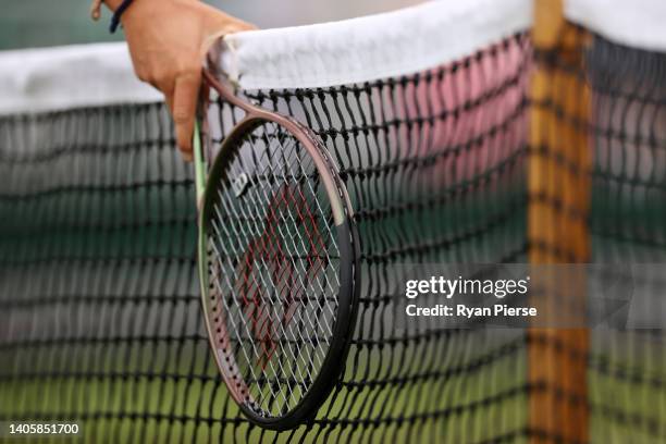 Detail view of a Wilson tennis racquet against the net on day three of The Championships Wimbledon 2022 at All England Lawn Tennis and Croquet Club...