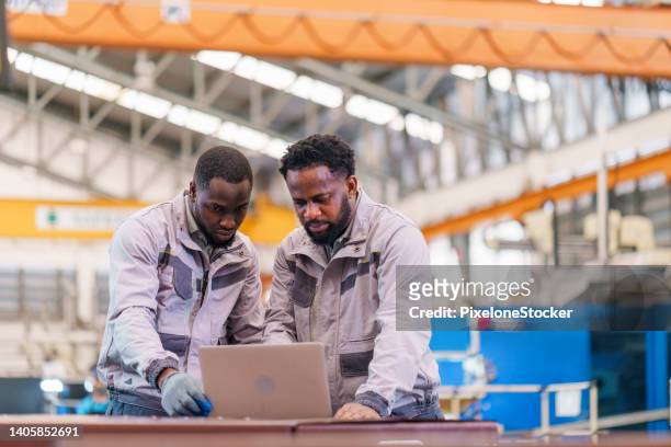 african man technicians using laptop working together at factory. - production line worker stock pictures, royalty-free photos & images
