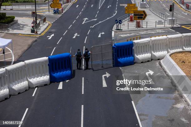 Police officer wait for guests to enter hotel for quarantine outside the Hong Kong Convention and Exhibition Center ahead of the handover anniversary...