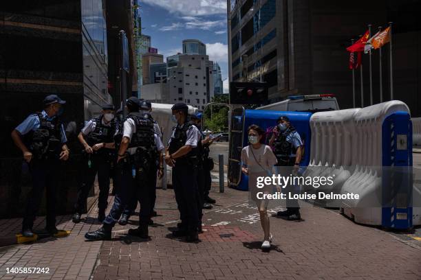Pedestrian walks past police officers and water barriers outside the Hong Kong Convention and Exhibition Center ahead of the 25th handover...