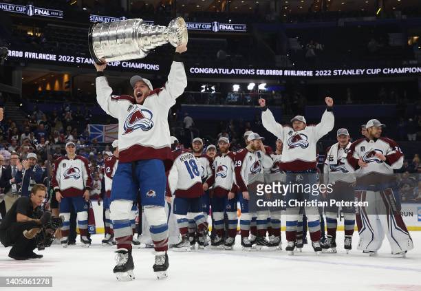 Jacob MacDonald of the Colorado Avalanche lifts the Stanley Cup in celebration after Game Six of the 2022 NHL Stanley Cup Final at Amalie Arena on...