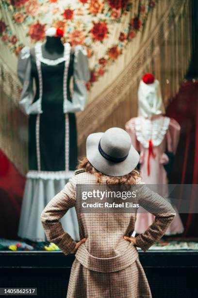 stylish woman looking at the shop window with some popular clothes from madrid - faze rug stockfoto's en -beelden