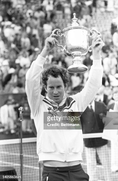 John McEnroe holds trophy after he beat Ivan Lendl 6-3, 6-4, 6-1 at Flushing Meadows.