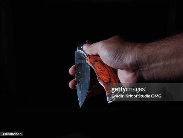 hand folding knife against black background - swiss army knife stock pictures, royalty-free photos & images