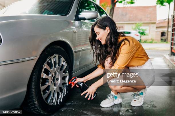 woman washing her car outdoors - car detailing stock pictures, royalty-free photos & images
