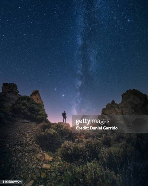 hiker following the path to the milky way in los roques de garcia, teide national park, tenerife - observation point fotografías e imágenes de stock