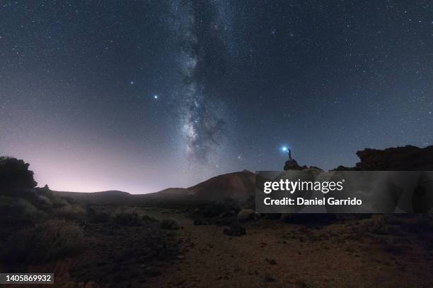 man lighting up the stars in the sky in teide national park - national night ストックフォトと画像