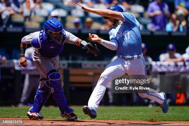 Hunter Dozier of the Kansas City Royals is tagged out at home plate by Meibrys Viloria of the Texas Rangers during the first inning at Kauffman...