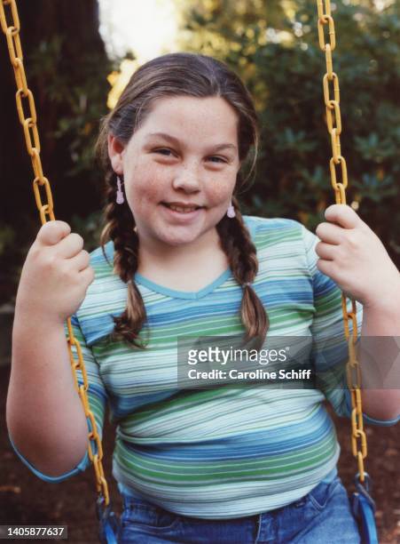 a young girl with freckles on a swing - young chubby girl photos et images de collection