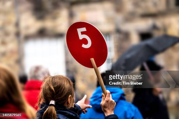 tour guide holding up sign and pointing. - tour guide stock pictures, royalty-free photos & images