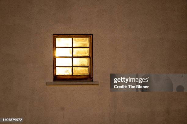illuminated window on simple exterior wall. - burns night scotland stock pictures, royalty-free photos & images