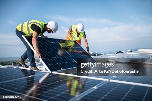 Two engineers installing solar panels on roof. Two engineers installing solar panels on roof.