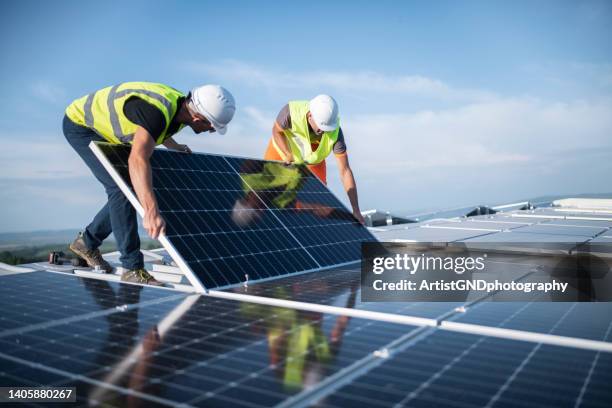 two engineers installing solar panels on roof. - underhållstekniker bildbanksfoton och bilder