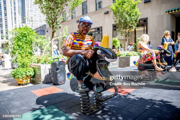 Artist Derrick Adams sits on the newly installed Funtime Unicorns at the Channel Garden in Rockefeller Center on June 29, 2022 in New York City.