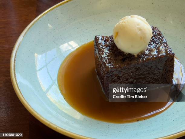a dessert of sticky toffee pudding layer cake garnished with ice cream - pudding stock pictures, royalty-free photos & images