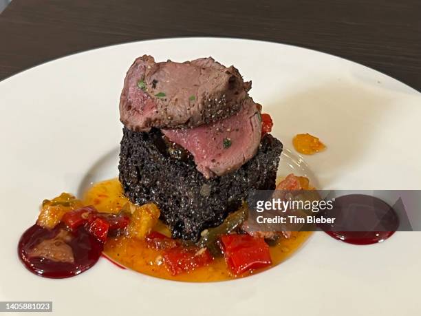 sliced filet beef venison, cooked medium rare, over black pudding haggis with vegetable sauce - haggis stock pictures, royalty-free photos & images