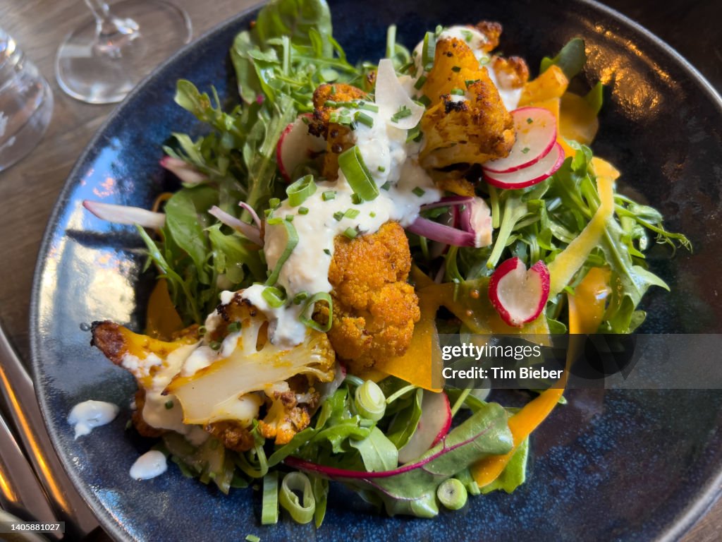 Fresh leafy salad with baked cauliflower radishes and a light dressing