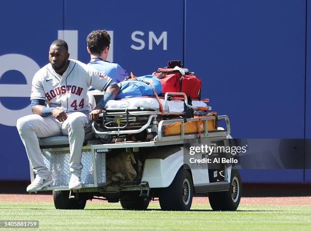 Yordan Alvarez of the Houston Astros is carted off the field after crashing into Jeremy Pena who made a catch hit by Dominic Smith of the New York...