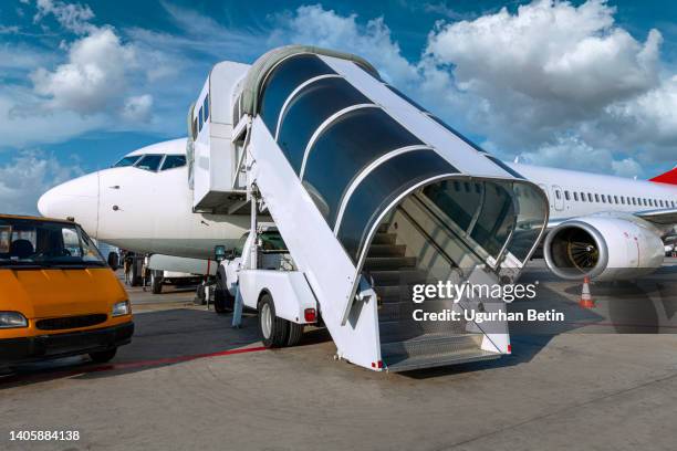 passenger ladder docked at the gate of a passenger plane. - passenger boarding bridge stock-fotos und bilder