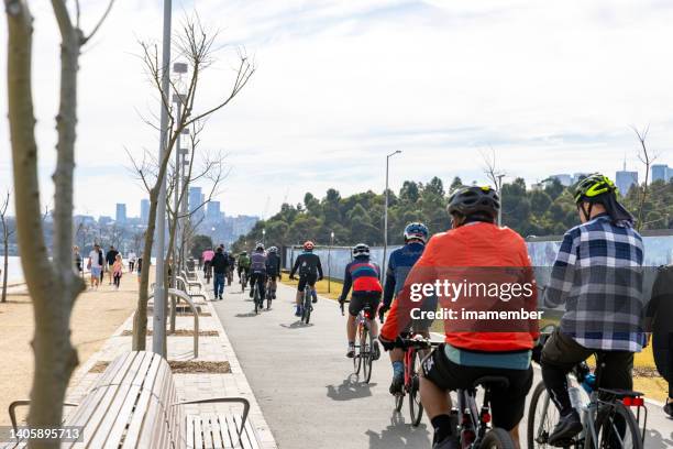 group of cyclists and people enjoiyng sunny day in city, copy space - bicycle lane stock pictures, royalty-free photos & images