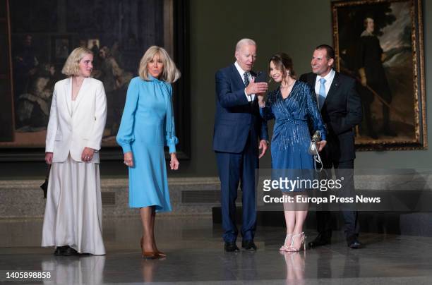 President Joe Biden shows his phone to New Zealand Prime Minister Jacinda Ardern on his arrival at the informal transatlantic dinner for heads of...