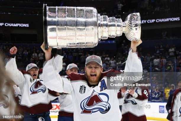 Nathan MacKinnon of the Colorado Avalanche carries the Stanley Cup following the series winning victory over the Tampa Bay Lightning in Game Six of...