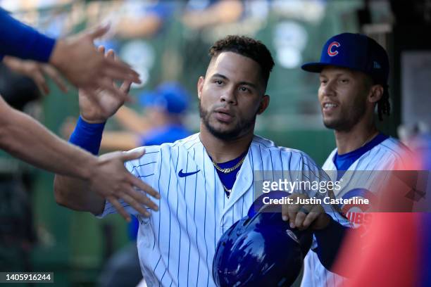 Willson Contreras of the Chicago Cubs celebrates with teammates in the dugout after scoring a run during the first inning in the game against the...