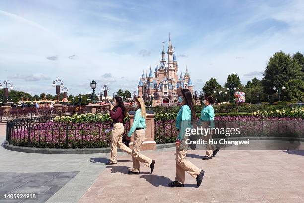 Staff members walk in front of the Enchanted Storybook Castle at Shanghai Disneyland on June 30, 2022 in Shanghai, China. Shanghai's Disneyland theme...
