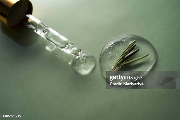 a drop of cosmetics gel with rosemary on a green background. - romero fotografías e imágenes de stock