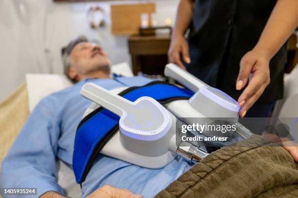 man getting radio frequency therapy at the spa targetting his abdominal body fat - sculpture imagens e fotografias de stock