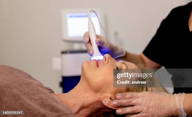 mujer en el spa recibiendo un tratamiento de belleza de terapia de luz en su cara - antiarrugas fotografías e imágenes de stock