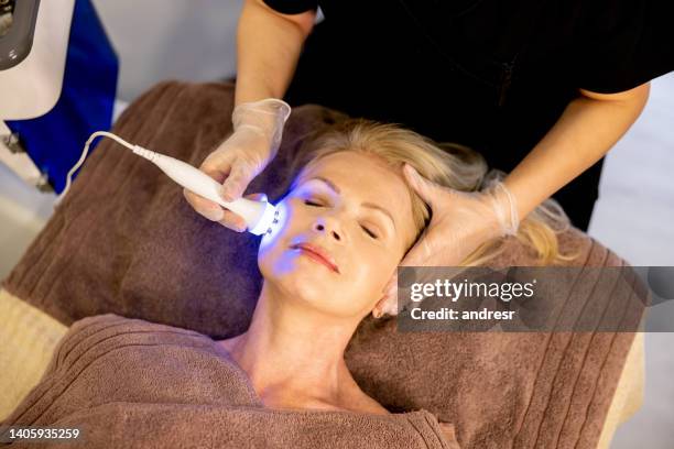 woman at the spa getting a light therapy treatment on her face - led light stock pictures, royalty-free photos & images