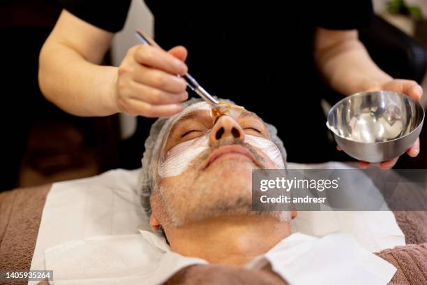 man at the spa getting a facial treatment - facial cleanse stock pictures, royalty-free photos & images