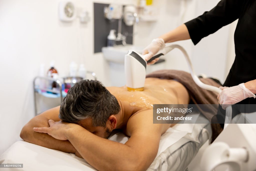 Uomo che riceve un trattamento di depilazione sulla schiena in una spa